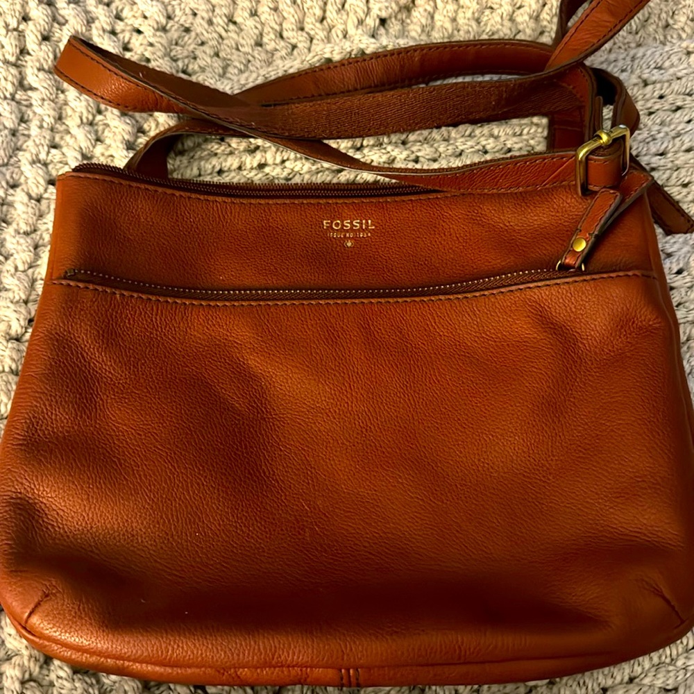 Brown Fossil crossbody purse with outside compartments on the outside.
